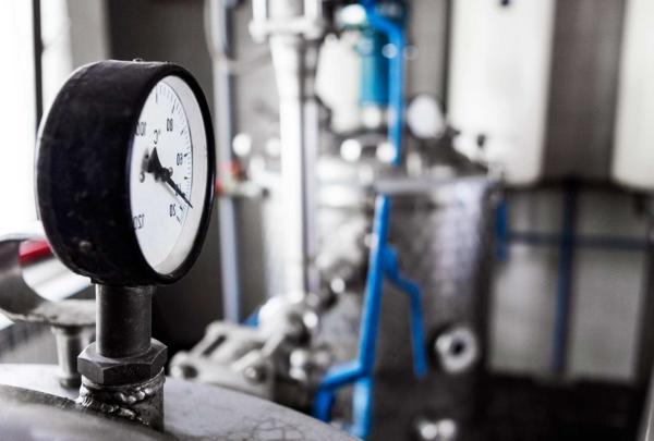 Distillery equipment. Temperature gauge sits atop metal vessel.